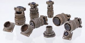 A group of various olive drab MIL-DTL-26482 circular military connectors, including plugs and square-flange receptacles, showing different sizes and pin configurations.